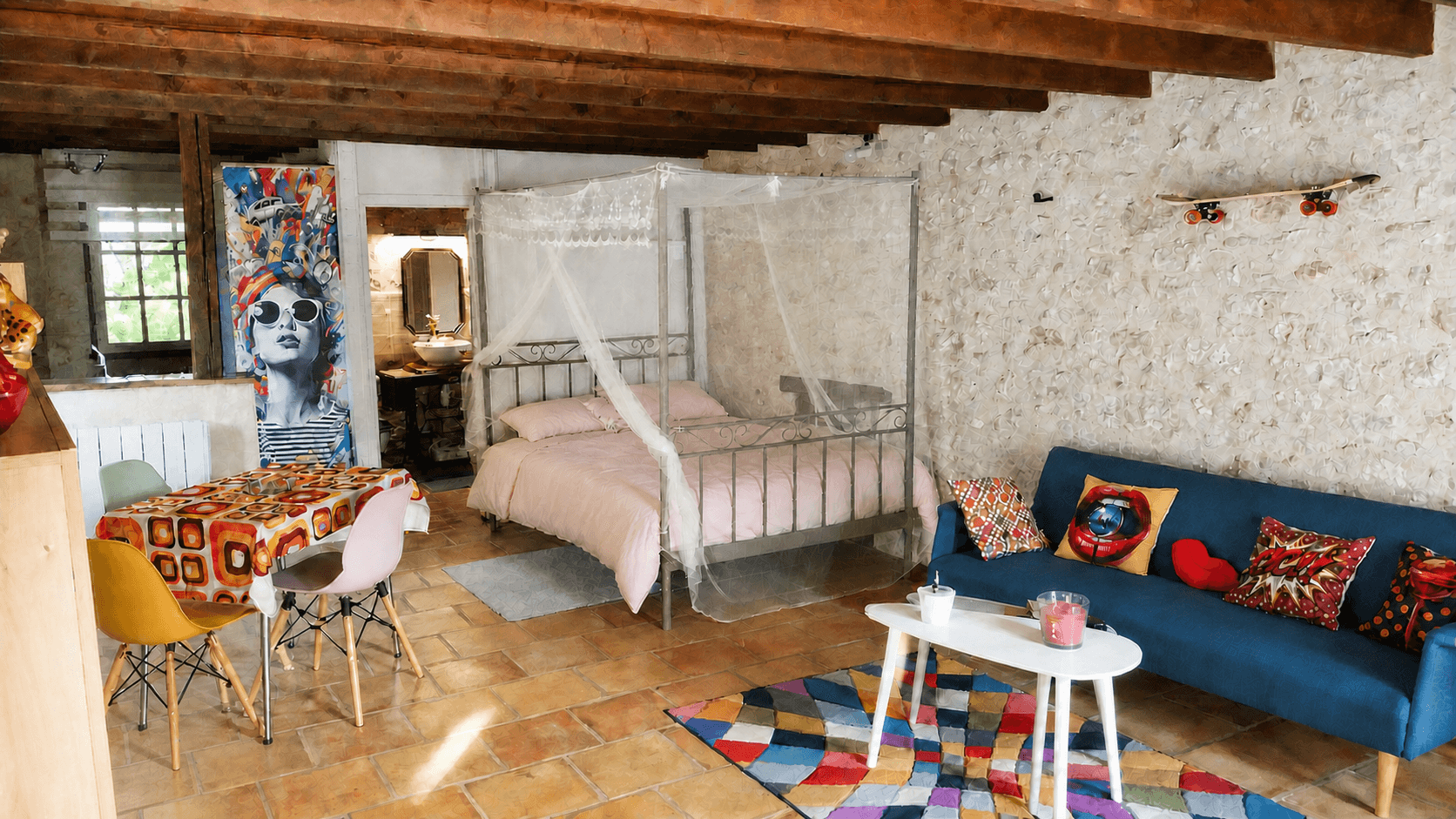 L’intérieur chaleureux de L’Instant Suspendu, avec son lit à baldaquin et ses murs en pierre